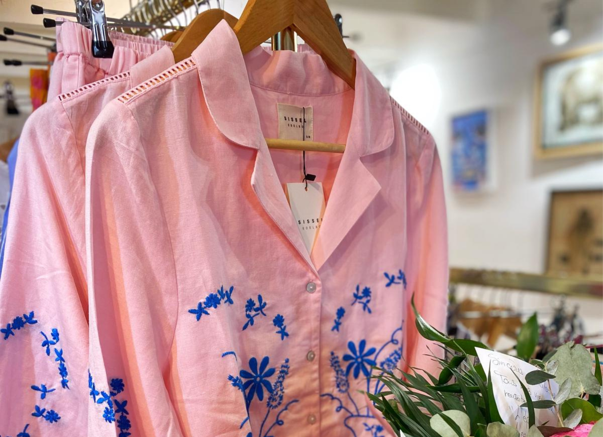 Chemise rose avec broderies florales bleues, disponible dans la catégorie vêtements de la boutique Mademoiselle K à Cassis. Élégante et légère, idéale pour l’été.