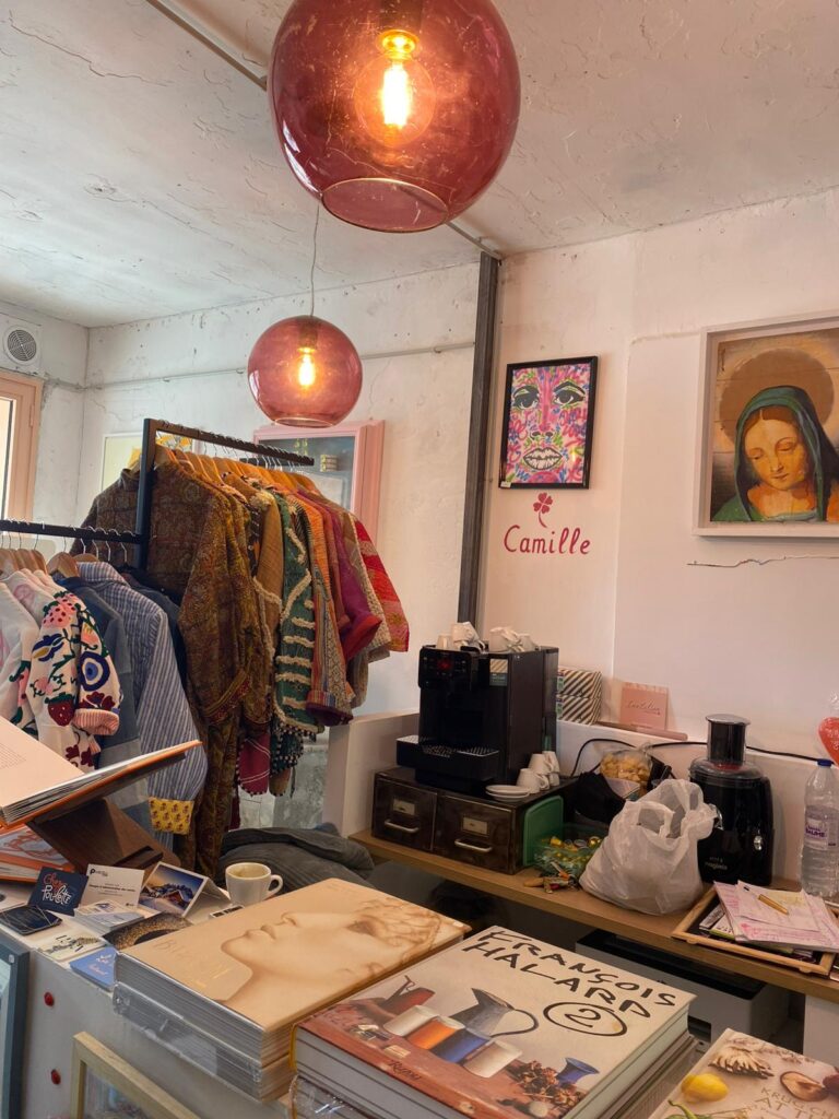 Vue intérieure de la boutique Mademoiselle K à Cassis, mettant en valeur des vêtements, des objets de décoration et des accessoires, avec une ambiance chaleureuse et colorée.