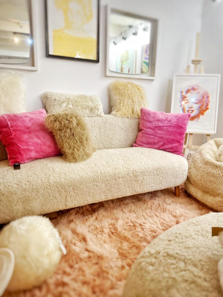 Coussins en fausse fourrure et canapé cosy, disponibles à la boutique Mademoiselle K à Cassis. Parfaits pour ajouter confort et style à votre décoration intérieure.